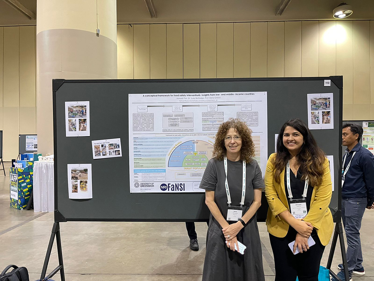 Prof. Delia Grace (L) and Himadri Pal stand next to Himadri’s poster at the symposium