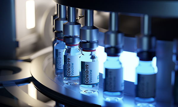 A close-up view of COVID-19 vaccine vials being processed on an automated production line. The vials are sealed with red caps, and the background is illuminated with blue lighting, indicating a sterile laboratory environment.